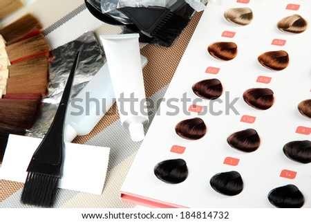 Hair dye kit on board with hair samples of different colors background