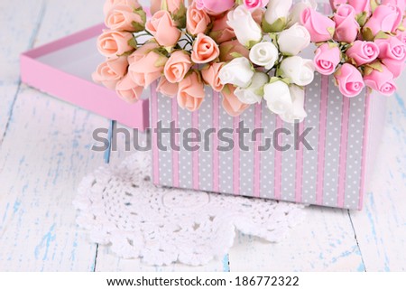 Flowers in gift box on wooden table close-up