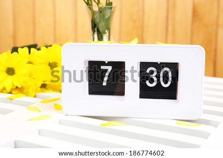Digital alarm clock on table, on wooden background
