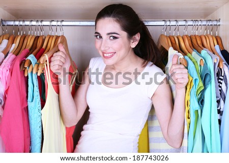 Young woman choose clothes in wardrobe at home