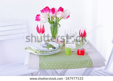 New table and chairs with place settings on light background