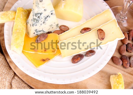Assorted cheese plate and wine glass on table background
