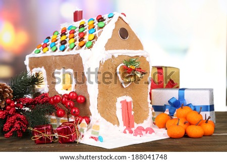 Beautiful gingerbread house with Christmas decor on wooden table