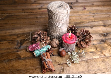 Composition with natural bump, candle, thread, cinnamon sticks on wooden background