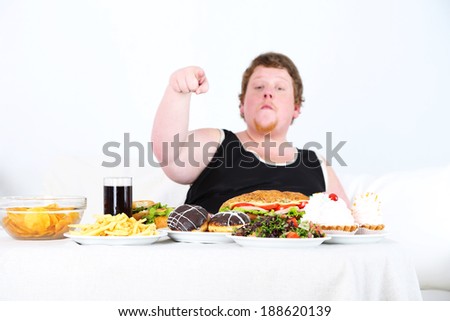 Fat man has a big lunch, on home interior background
