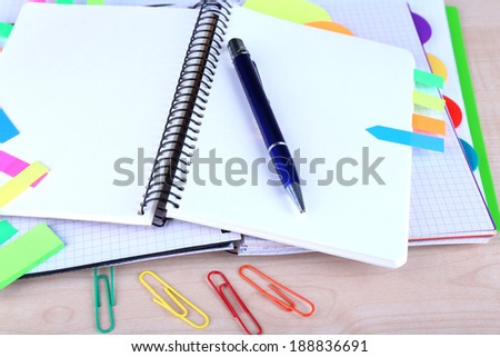 Notebook, pen, and stickers on wooden background