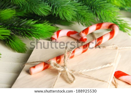 Christmas candy canes and letters for Santa, on color wooden background