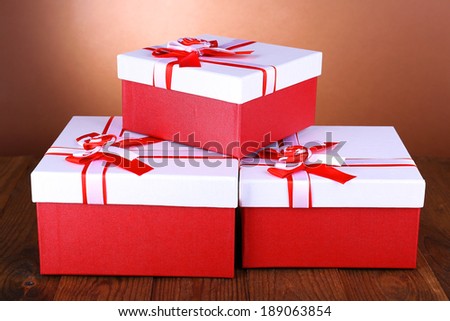 Beautiful gift boxes on table on brown background