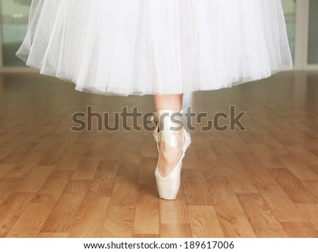 Ballerina legs in pointes in dancing hall