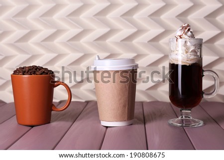 Assortment of coffee drinks on wooden table, on light background