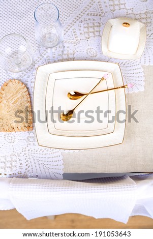 Composition with teapot, saucer and spoons on wooden table background
