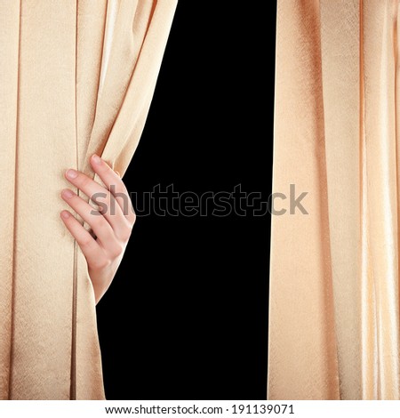 Hand opening curtain on black background