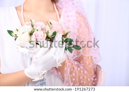 Beautiful bride in white gloves holding wedding bouquet, close-up