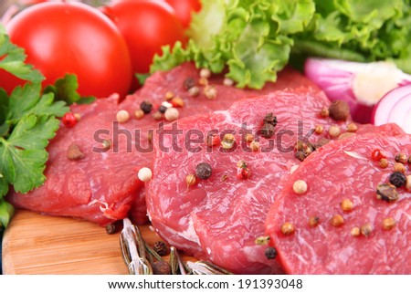 Raw beef meat with vegetables on table close up