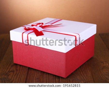 Beautiful gift box on table on brown background