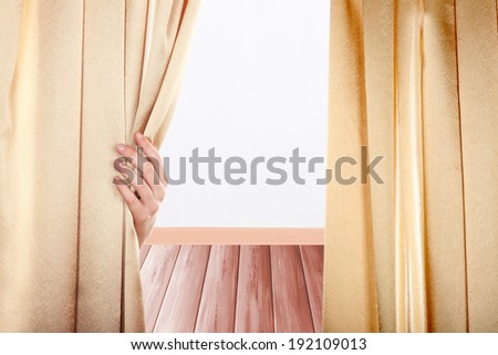 Hand opening curtain on room background