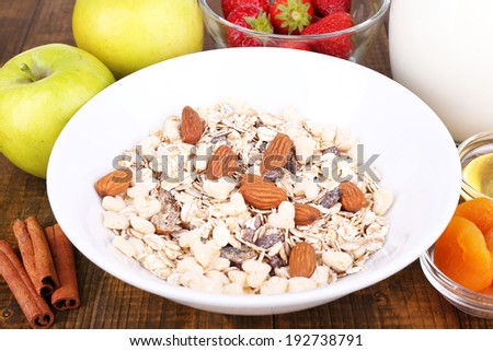 Healthy cereal with milk and fruits on wooden table