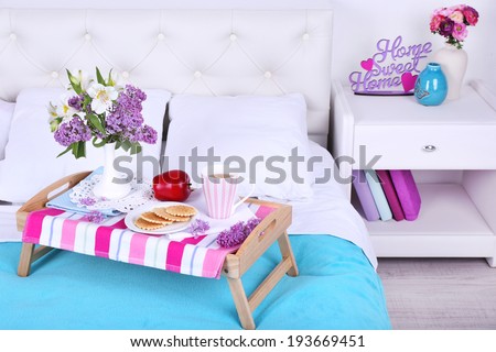 Light breakfast and beautiful bouquet on bed
