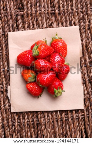 Ripe sweet strawberries  on paper napkin on wicker mat background