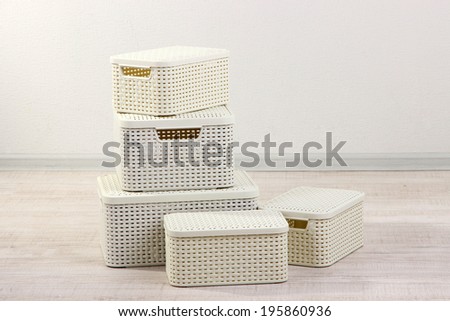 Plastic baskets for storing things in floor on room background