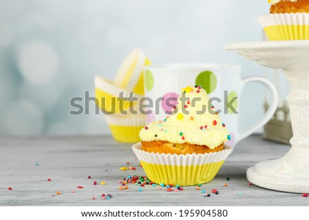Tasty cup cakes with cream on grey wooden table