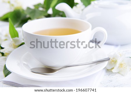 Cup of tea with jasmine on table close-up