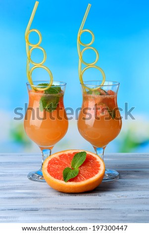 Grapefruit cocktail with cocktail straw on bright background