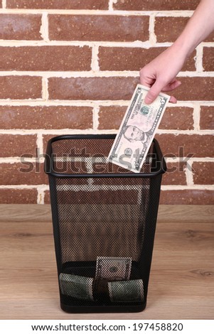 Throwing away your money on brick wall background