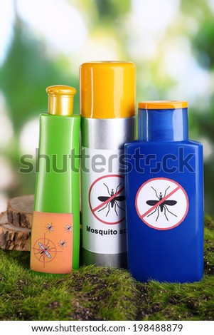 Bottles with mosquito repellent cream on nature background