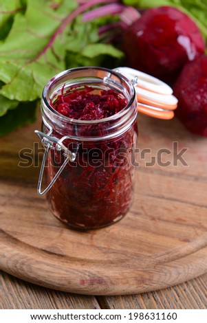 Grated beetroots in jar on table close-up
