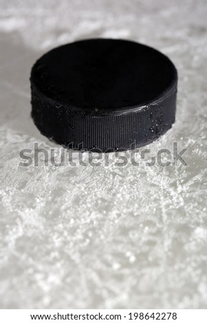 Black hockey puck on ice rink background