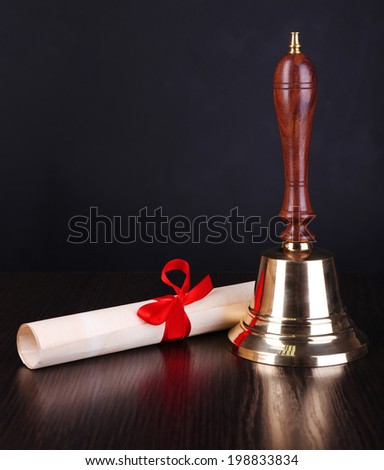 Gold retro school bell with scroll on dark background