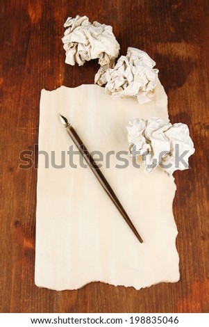 Crumpled paper balls with ink pen on wooden background