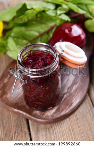 Grated beetroots in jar on table close-up