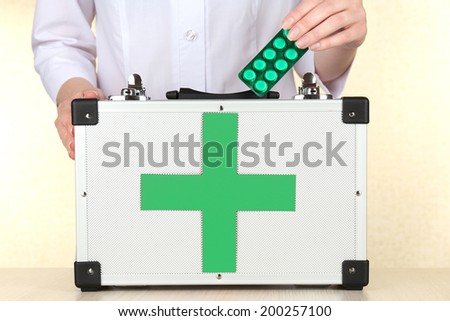 Nurse holding first aid kit, close up