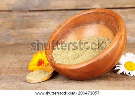 Dry henna powder in bowl on wooden table