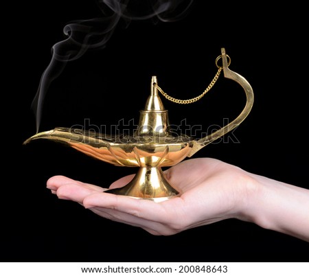 Magic lamp in female hands isolated on black