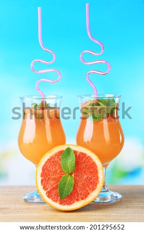 Grapefruit cocktail with cocktail straw on bright background