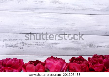 Beautiful pink peonies on color wooden background