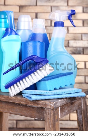 Cleaning products on shelf on bricks wall background