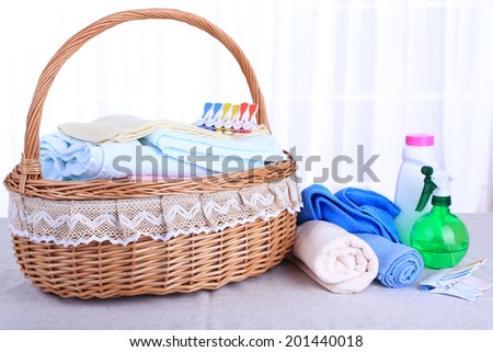Colorful towels in basket on table, on light background