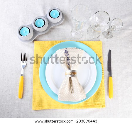 Dining table setting with lavender flowers on light tablecloth background