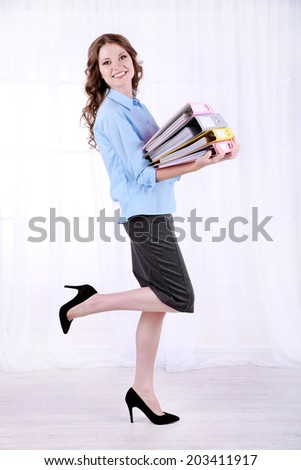 Young business woman with office folders in room