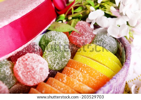 Present box with sweets and flowers close up
