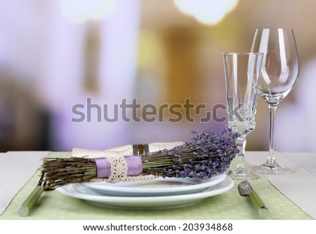 Dining table setting with lavender flowers on table, on bright background