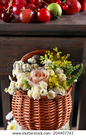 Basket of flowers hanging on wooden shelf close up