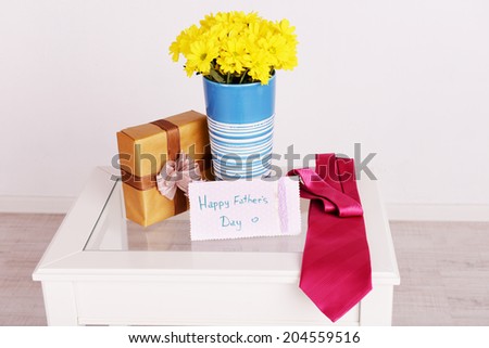 Bouquet of flowers, gift box and tie on Fathers Day in room