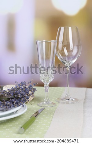 Dining table setting with lavender flowers on table, on bright background