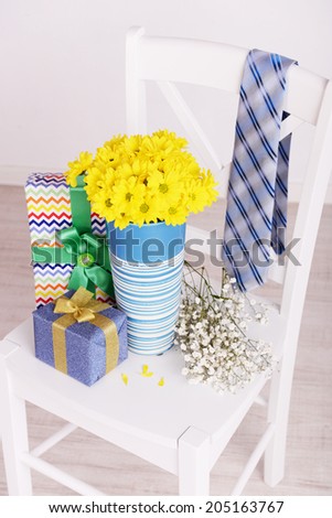 Bouquet of flowers, gift boxes and tie on Fathers Day in room