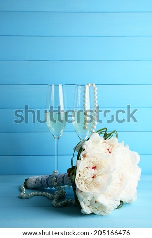 Beautiful wedding bouquet and wine glasses on  color background